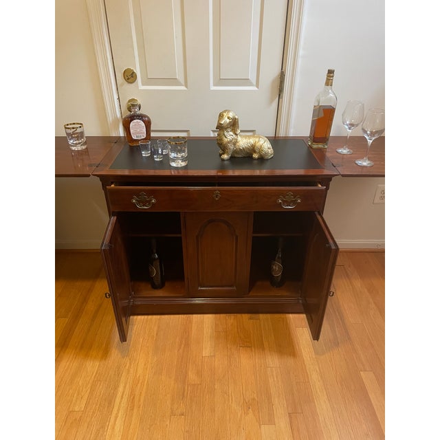 An exceptional American traditional flip-top rolling buffet server and dry bar cabinet by luxury manufacturer Drexel...