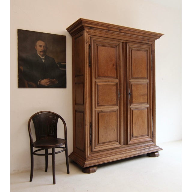 A north French or Belgian provincial two-door cabinet from the early 19th century. Solidly crafted in oak with ornate...