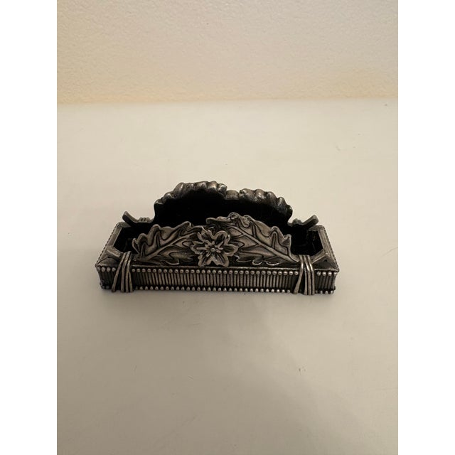 Pewter business card holder with leaves on both sides and felt on the bottom. It stands at 4.25" wide, 1.5" deep and 1.5"...