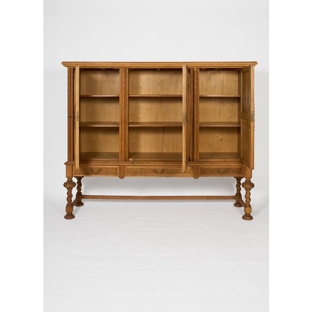 Oak Sideboard with Carved Panels and Turned Legs A beautifully detailed vintage oak sideboard distinguished by its carved...