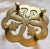 Vintage brass trivet with a floral shape, four feet and etched details.