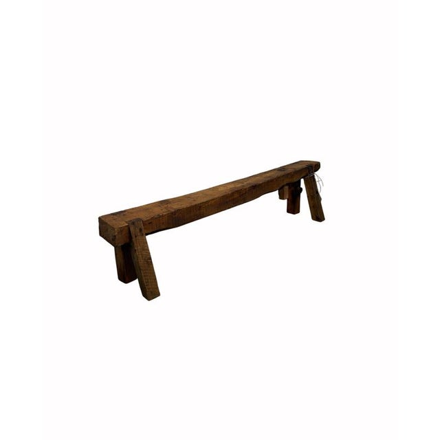 Sturdy 19th-century mountain larch bench, featuring a solid structure and simple, functional construction. The bench rests...