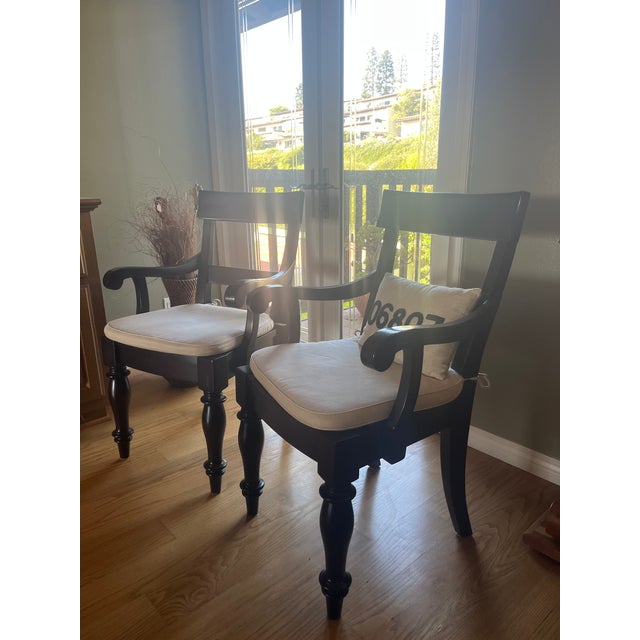 Two elegant armchairs in solid mahogany with a rich espresso finish. Each chair features gracefully turned legs, a classic...