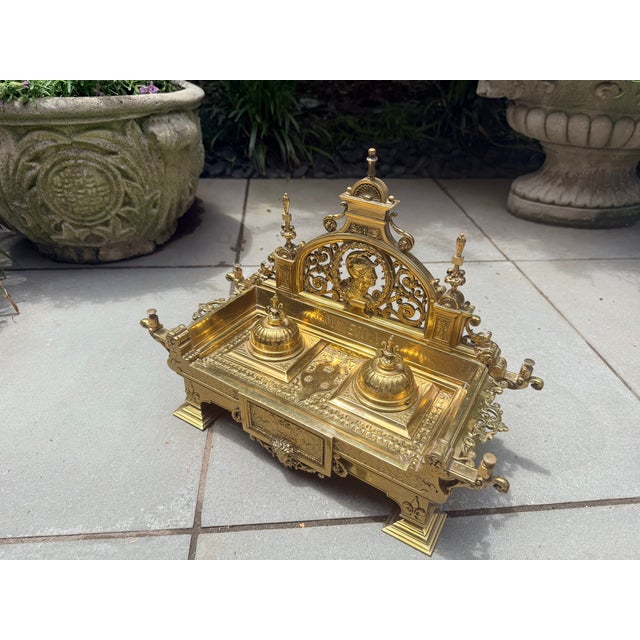 Elevate your workspace with this exceptionally crafted antique-style Neoclassical brass double inkwell. Richly detailed...