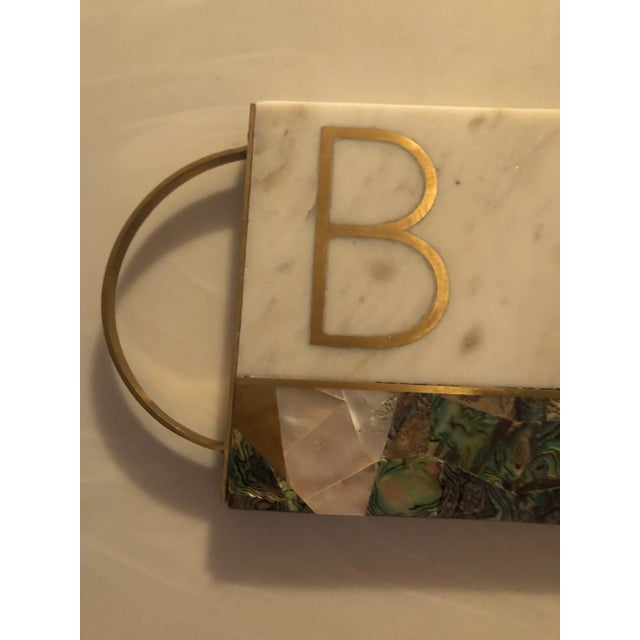 Anthropology marble , papua shell , mother of pearl , and brass monogram cheese board. Made in India . Measures 17.26” x...