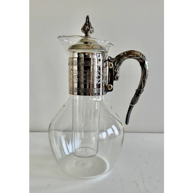 Elegant silver and glass pitcher for hot and cold beverages. The metal parts are silver because they tarnish, but I do not...