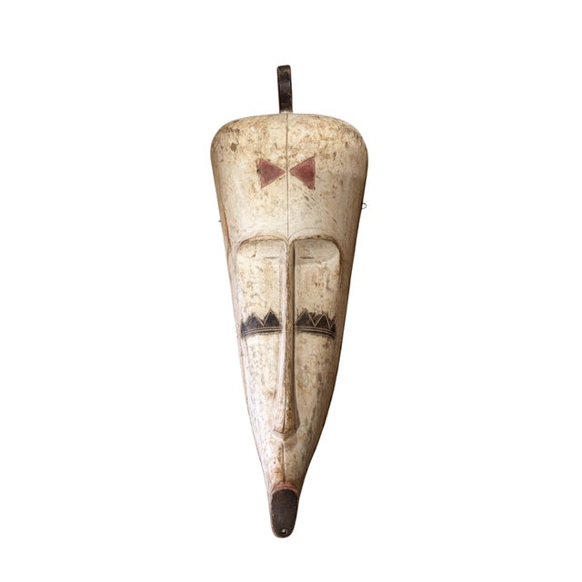 Superb vintage Fang mask carved from a single piece of heavy wood, featuring an elongated heart-shaped face rendered in...