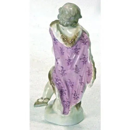 Antique porcelain Meissen cherub figurine wrapped in a cloak. Marked with crossed swords logo at the bottom.