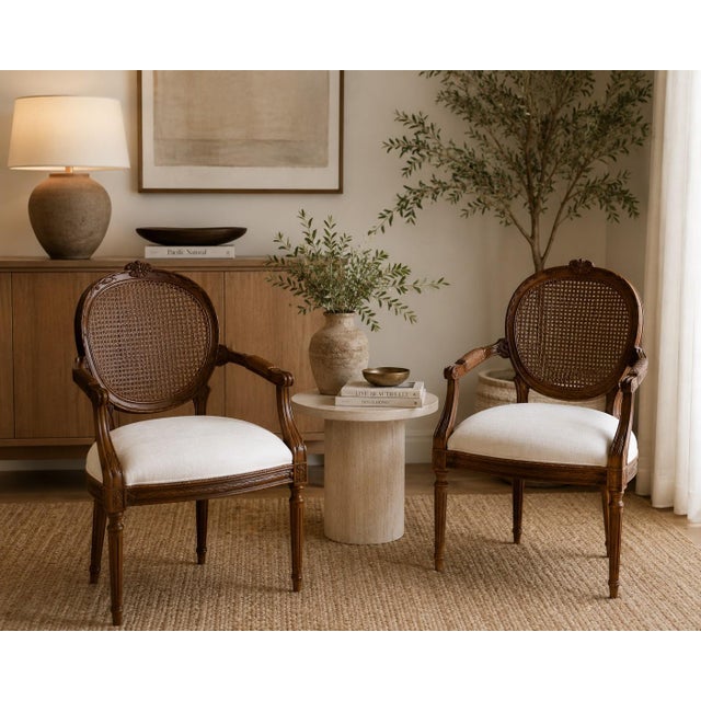 Elevate your space with this beautifully restored pair of vintage French Provincial cane back accent chairs. Featuring...