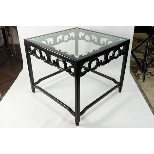 A pair of chinoiserie style square accent side tables featuring wooden fretwork frames in a mahogany finish with beveled...