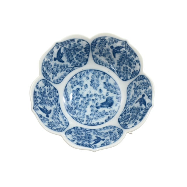 Vintage porcelain six inch lotus flower bowl with subtly ribbed petals in a blue and white pattern of birds in the trees....