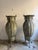 A pair of 20th-century ornamental amphorae. These large vases are made of hammered copper with vertical segments and have...