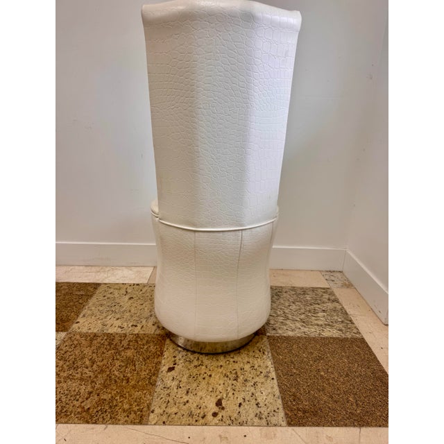 Single white vanity chair upholstered in faux crocodile embossed material with a tall curved back, round seat, and...