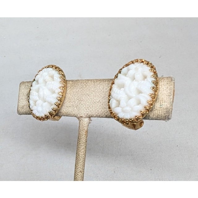 1960s goldtone prong set oval faux-carved white jade clip earrings. Marked "NAPIER PAT. PEND." on the clips. Measure: 7/8...
