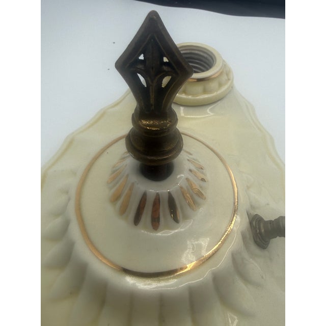 A charming vintage glazed porcelain ceiling fixture featuring an elongated sculptural form, glossy ivory/cream finish,...