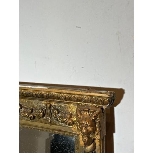 Impressive antique giltwood mirror featuring rich classical ornamentation and sculptural lion mask corner details. The...