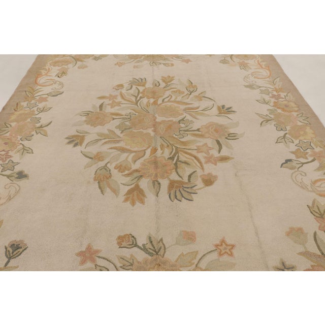 Handmade in wool, this antique hooked rug measures 8x11, circa 1920-1930. The design features a central floral bouquet...
