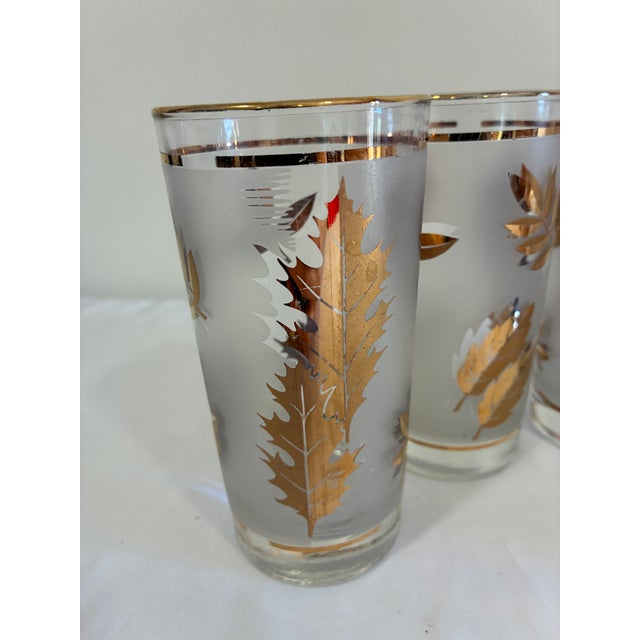 A decorative set of five vintage Libbey glass tumblers featuring frosted grounds embellished with metallic gold foliage...