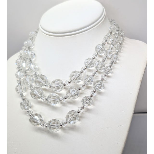 1950s rhodium plated 3-strand cut glass breaded necklace with round box clasp with single round clear rhinestone in the...