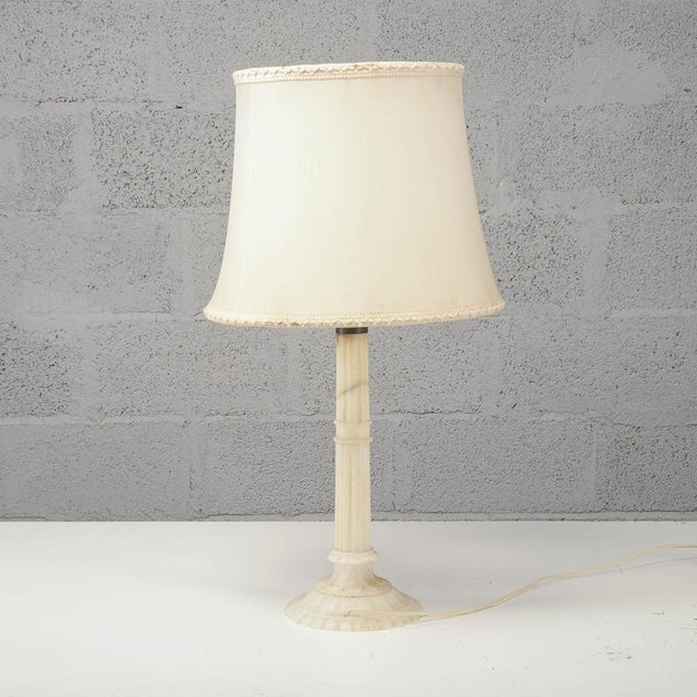 This vintage table lamp, dating from the mid-20th century, exudes understated elegance inspired by neoclassical style. The...