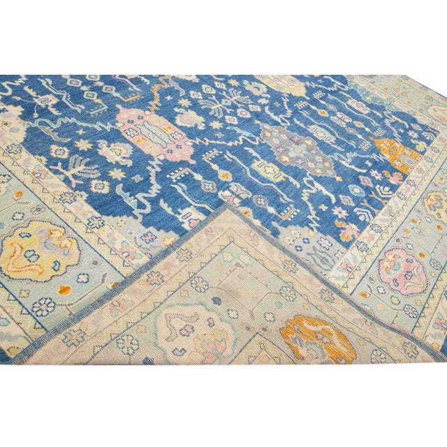 Beautiful modern Oushak hand-knotted wool rug with a navy blue field. This Oushak rug has a multicolor accents layout a...