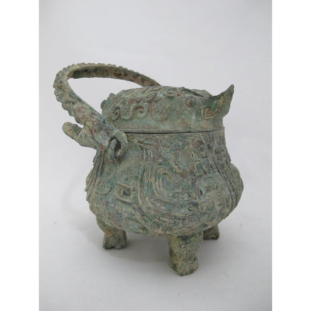 Antique replica of a Shang Dynasty Chinese bronze ware ritual wine pot or you. Fitted lid and prominent swing handle with...