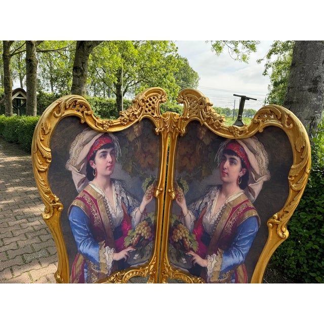 A striking 1960 French Louis XVI-style folding screen, crafted from carved solid beechwood and finished in a rich antique...
