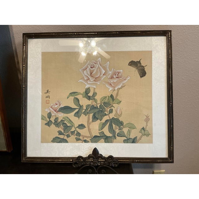 Vintage framed East Asian botanical painting, featuring soft pink roses, delicate green foliage, and a dark butterfly...