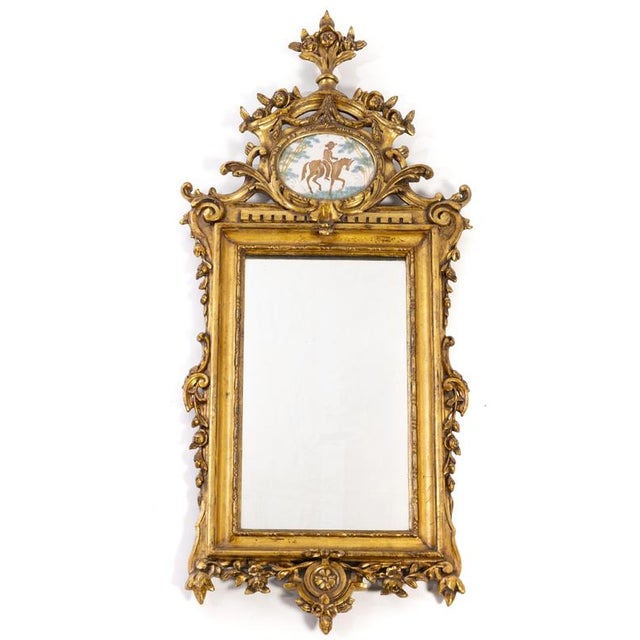 WALL MIRROR Portuguese, 19th century, D. José/D. Maria style, carved and gilded wood, topped with a polychrome earthenware...