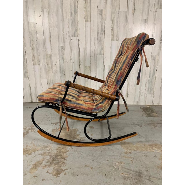 Very good original condition black metal with multi- colored patchwork upholstery. Solid oak turned armrest and header...