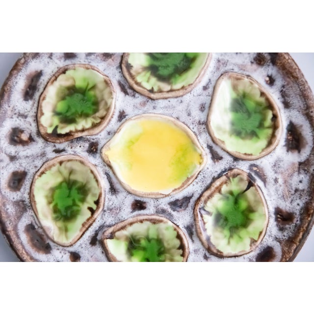 A vibrant Mid-Century French green and yellow majolica oyster plate in the Vallauris style, six wells with a lemon center.