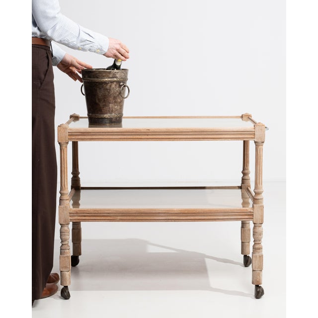 A practical oak bar cart mounted on casters for easy mobility. The natural wood construction adds warmth while maintaining...