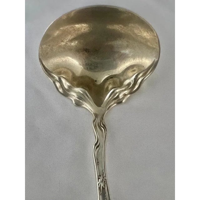 A sterling silver Art Nouveau Serving Spoon by George W. Shiebler & Company. This piece showcases the distinctive and...