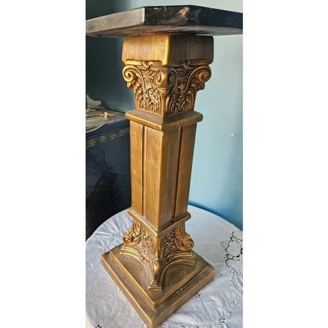 Very heavy and solid. Gold finish pedestal, topped with marble. Corinthian detail at top and bottom of the column.