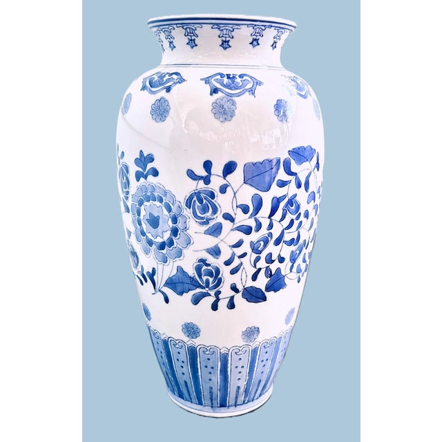 Hand-Painted Blue and White Porcelain Vase Elegant and tall porcelain vase with hand-painted cobalt floral motif on a...