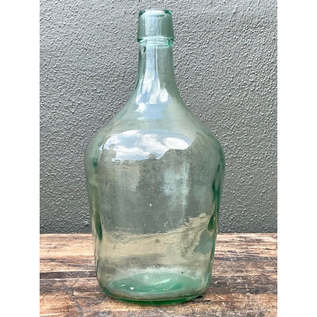 This elegant vintage hand-blown glass demijohn captures the timeless charm of European cellar aesthetics. Featuring a...
