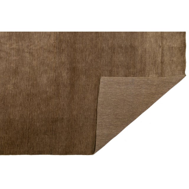 Discover our stunning handcrafted Gabbeh-style wool rug, showcasing a rich Chestnut brown design. Proudly part of our...
