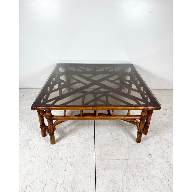 Vintage square rattan coffee table. Chinese chippendale fretwork designs with leather wrapped joints. 0.25" smoked glass top.