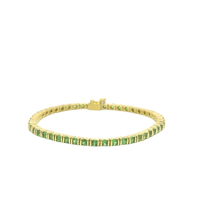 A contemporary tennis bracelet by Jean Vitau, featuring vibrant green tsavorite stones. The bracelet is adorned with round...