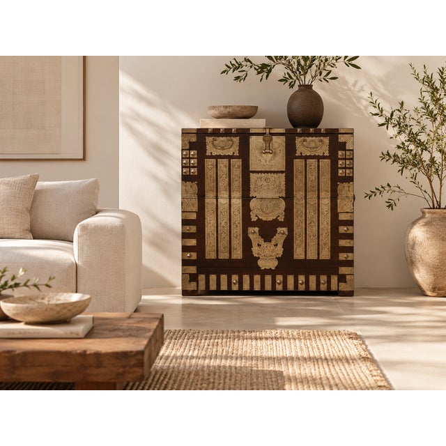 Brass does the work on this chest: engraved plates, pyramid studs and strap fittings cover a dark-stained front, with...