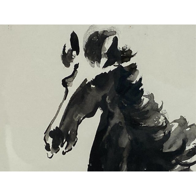 A framed Japanese ink wash painting of a galloping horse shown mid-stride with raised forelegs, flowing mane and sweeping...