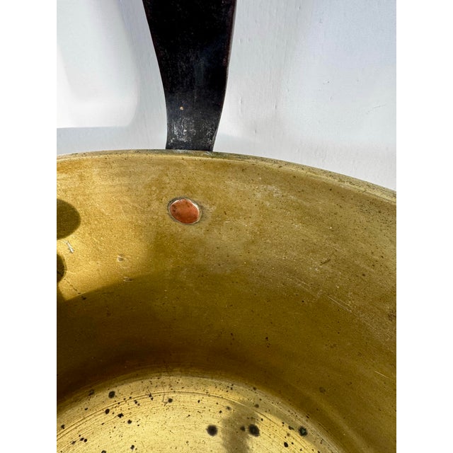 A substantial antique French brass preserving pot, traditionally known as a bassine à confiture, featuring a hand-forged...