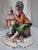 A fine, highly detailed vintage hand-painted Italian polychrome porcelain figurine depicting a street organ grinder with...