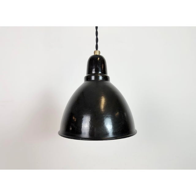 Industrial black enamel ceiling light made in former Czechoslovakia during the 1950s. White enamel inside the shade. Metal...
