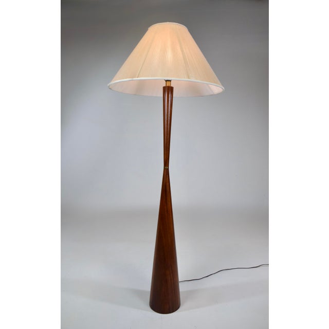 Solid walnut hourglass-shaped floor lamp designed by Raymond Pfennig for Zina Lamp Co. (California), circa 1960. Boasting...