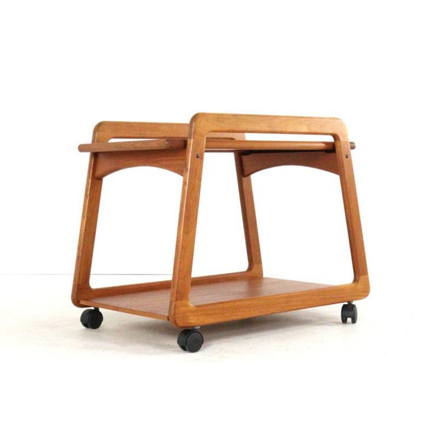 A beautifully designed teak trolley. This trolley owes its lovely, timeless look to the flowing lines in its design; both...