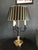 French Bouillotte lamp with its original painted black and gold tole shade. This beautiful lamp has a circular brass base...