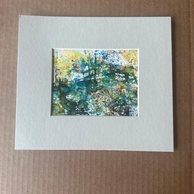 This original watercolor painting captures the beauty of a lush, sunlit forest with rich greens, warm golden tones, and...
