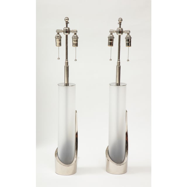 Pair of cylindrical chrome and glass lamps by Laurel. The polished chrome lamps have frosted glass inserts and they have...