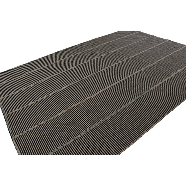 Handwoven in wool, a 10×14 Kilim in Black with Brown and Green accents, from a bold new line of contemporary flatweaves,...